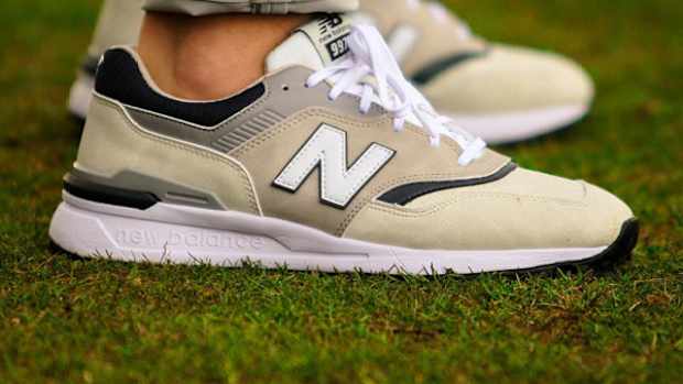 Side view of tan and white New Balance golf shoes.